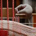 전통 수직기로 정교한 직물을 짜는 장인의 손.